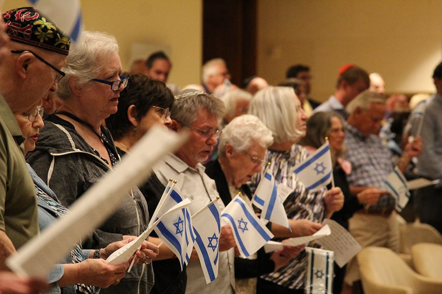 Attendees wave small Israeli flags in support of Israel at a solidarity vigil held on Oct. 10 at the Beth-El Congregation in Fort Worth